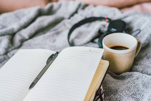 ノートとコーヒーが並ぶ落ち着いたデスクの風景。日々の積み重ねや習慣づくりをイメージした写真。