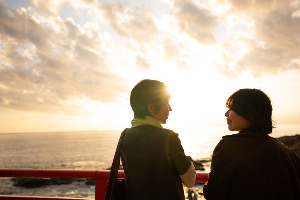 夕景の中で会話する日本人親子。母との関係や家族のつながりを考えるイメージ