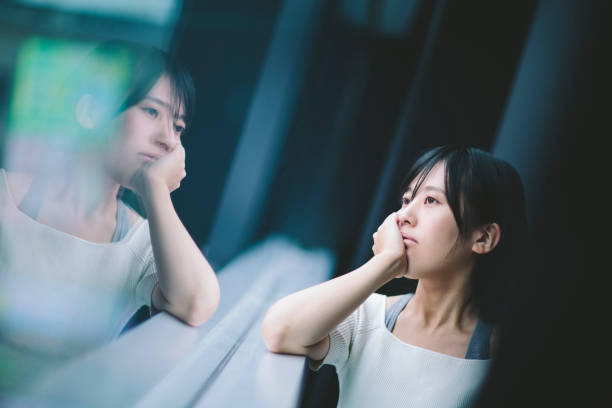 窓辺で物思いにふける女性